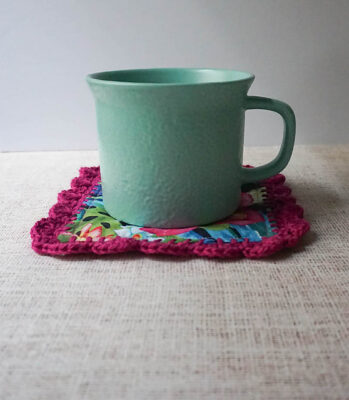 Easy Sew Mug Rug with Crochet Border by Marie Segares/Underground Crafter. The coaster is shown in a pretty floral fabric with a scalloped crochet edge.
